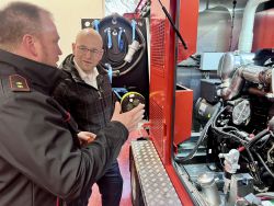 Wehrführer Thomas Eggebrecht erklärt dem Landrat Christian Müller die Funktionsweise des neuen Notstromaggregats. Foto: Hanno Taufenbach/Landkreis Prignitz
